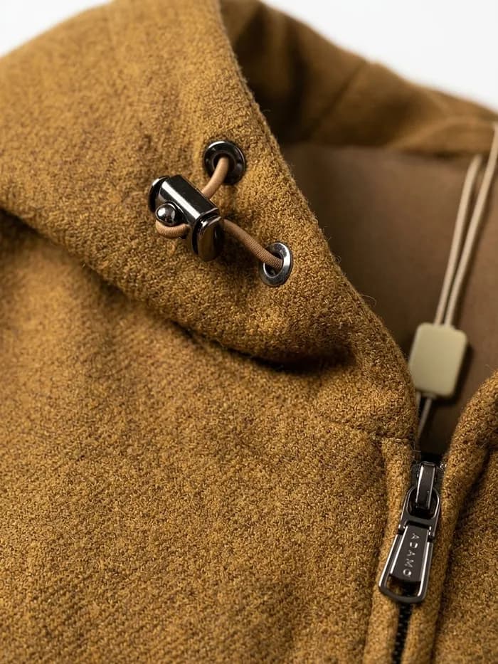 A close crop of the jacket's collar, drawcord toggle and zip pull